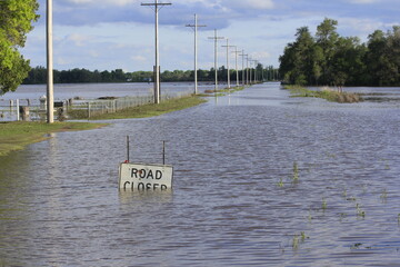 A Kansas flooded country road with blue sky and clouds with tree's west of Hutchinson Kansas USA out in the country.