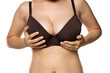 © vladimirfloyd - A woman adjusts her large breasts in the bra