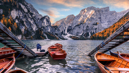 Fototapete - Autumn nature landscape. Spectacular famous place with typical wooden boats. View on Braies alpine lake during sunrise. Lago di Braies. Dolomites Alps. Italy. Popular Iconic location for photographers