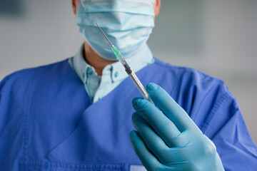 Wall Mural - Close up of doctor's hand in medical gloves with a syringe ready for injection