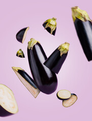 Wall Mural - Fresh eggplants cut into pieces flying and levitate in the air against pastel violet background. Abstract or surreal vegetable motion composition. Creative healthy protein food concept.