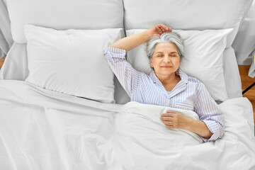 Sticker - old age and people concept - senior woman sleeping in bed at home bedroom