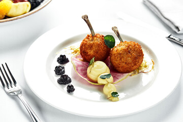 Two Chicken Kievs on a light plate, with potatoes and lettuce, author's serving of Kiev cutlets