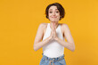© ViDi Studio - Young woman 20s with bob haircut wearing white tank top shirt hands folded in prayer gesture, begging about something isolated on yellow color background studio portrait. People lifestyle concept