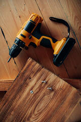 Handyman in blue uniform works with electricity automatic screwdriver. House renovation conception.