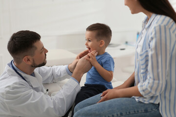 Poster - Mother and son visiting pediatrician in hospital. Doctor examining little boy