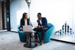 © Wavebreak Media - Diverse businessman and businesswoman discussing together while sitting at modern office