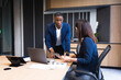 © Wavebreak Media - Diverse businessman and businesswoman discussing over digital tablet in meeting room at office