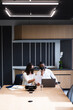 © Wavebreak Media - Diverse businessman and businesswoman wearing face masks discussing over a document at office