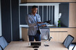 © Wavebreak Media - African american businessman reading documents while standing in meeting room at modern office