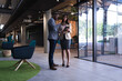 © Wavebreak Media - Diverse businessman and businesswoman discussing over digital tablet at modern office