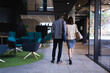 © Wavebreak Media - Rear view of diverse businessman and businesswoman walking in modern office