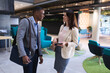 © Wavebreak Media - Diverse businessman and businesswoman smiling while discussing over digital tablet at office