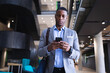 © Wavebreak Media - African american businessman using a smartphone while standing at modern office