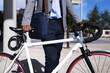 © Wavebreak Media - Mid section of african american businessman with bicycle standing at corporate park