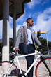© Wavebreak Media - Thoughtful african american businessman with bicycle standing at a corporate park