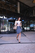 © Wavebreak Media - Caucasian businesswoman holding coffee cup smiling while using smartphone walking at corporate park