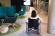 © Wavebreak Media - Rear view of disabled caucasian businesswoman sitting on wheelchair at modern office