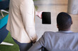 © Wavebreak Media - Mid section of businesswoman showing digital tablet to disabled businessman on wheelchair at office
