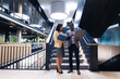 © Wavebreak Media - Diverse businessman and businesswoman discussing together standing near the stairs at office