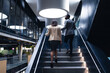 © Wavebreak Media - Rear view of diverse businessman and businesswoman climbing up the stairs at modern office