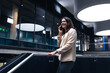 © Wavebreak Media - Caucasian businesswoman smiling while talking on smartphone standing near the stairs at office