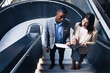 © Wavebreak Media - Diverse businessman and businesswoman discussing together while standing on the stairs at office