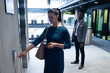 © Wavebreak Media - Caucasian businesswoman holding smartphone pressing the lift button at modern office