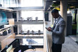 © Wavebreak Media - African american businessman using smartphone while standing in the corridor at modern office
