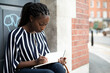 © Rawpixel.com - Woman sitting and taking notes in a doorway