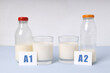 Two bottles and glass of milk different types.A1 and A2 milk variety