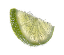 Slice Of Lime In Sparkling Water On White Background. Citrus Soda