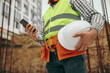 © kegfire - Construction technician using mobile phone on site
