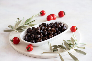 Black olive. Tasty organic black olives in the plate. Olive on marble floor