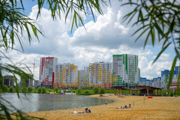 a beach on the shore of a lake with a beautiful city