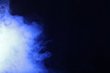 Poster - Artificial smoke in blue light on black background