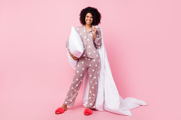 Wall Mural - Photo of funny pretty wavy dark skin lady dotted sleepwear dancing holding white blanket pillow isolated pink color background