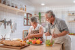 © Supachai - Lovely couple Asian elder happy and smiling cooking salad together for breakfast in the morning at home kitchen