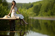 © BGStock72 - Relaxing young woman on wooden pier at the lake
