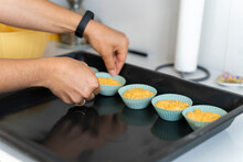 Detail Of Female Hands Placing Cupcakes On Oven Tray
