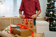 © Sergio Marcos/Stocksy - Unrecognizable man wrapping christmas presents