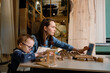© Milles Studio/Stocksy - Little boy with mom making wooden toy in workplace