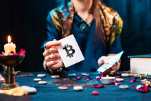 The Fortune Teller Shows A Card With The Bitcoin Currency. The Concept Of Unpredictable Cryptocurrency Exchange Trading