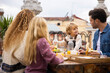 © VICTOR TORRES/Stocksy - Happy family having breakfast on terrace