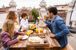 © VICTOR TORRES/Stocksy - Happy family having breakfast on terrace