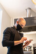 © Hernandez & Sorokina/Stocksy - Chef Holding Smartphone At Kitchen