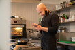 © Hernandez & Sorokina/Stocksy - Chef Checking Phone At Kitchen