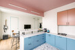 © Luciano Spinelli/Stocksy - Kitchen and living room of a colourful flat with a guitar hanging on the wall.
