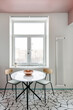 © Luciano Spinelli/Stocksy - A round table with two chairs in a scandinavian style kitchen in front of a window