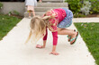 © Jennifer Bogle/Stocksy - Girl with chalk bouces on sidewalk
